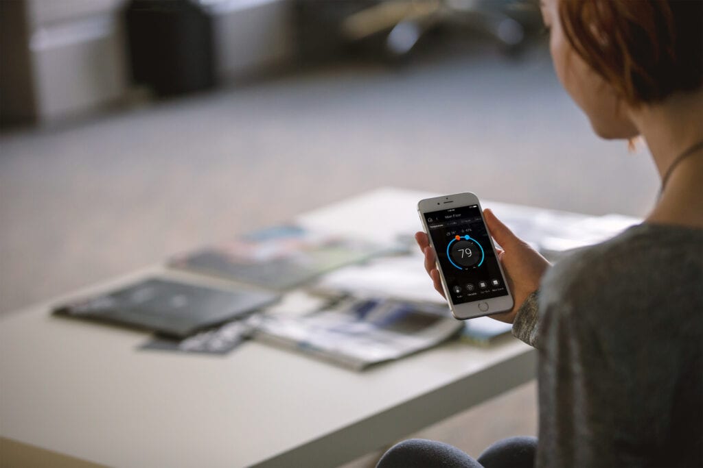 A person sitting at a table holding a phone.