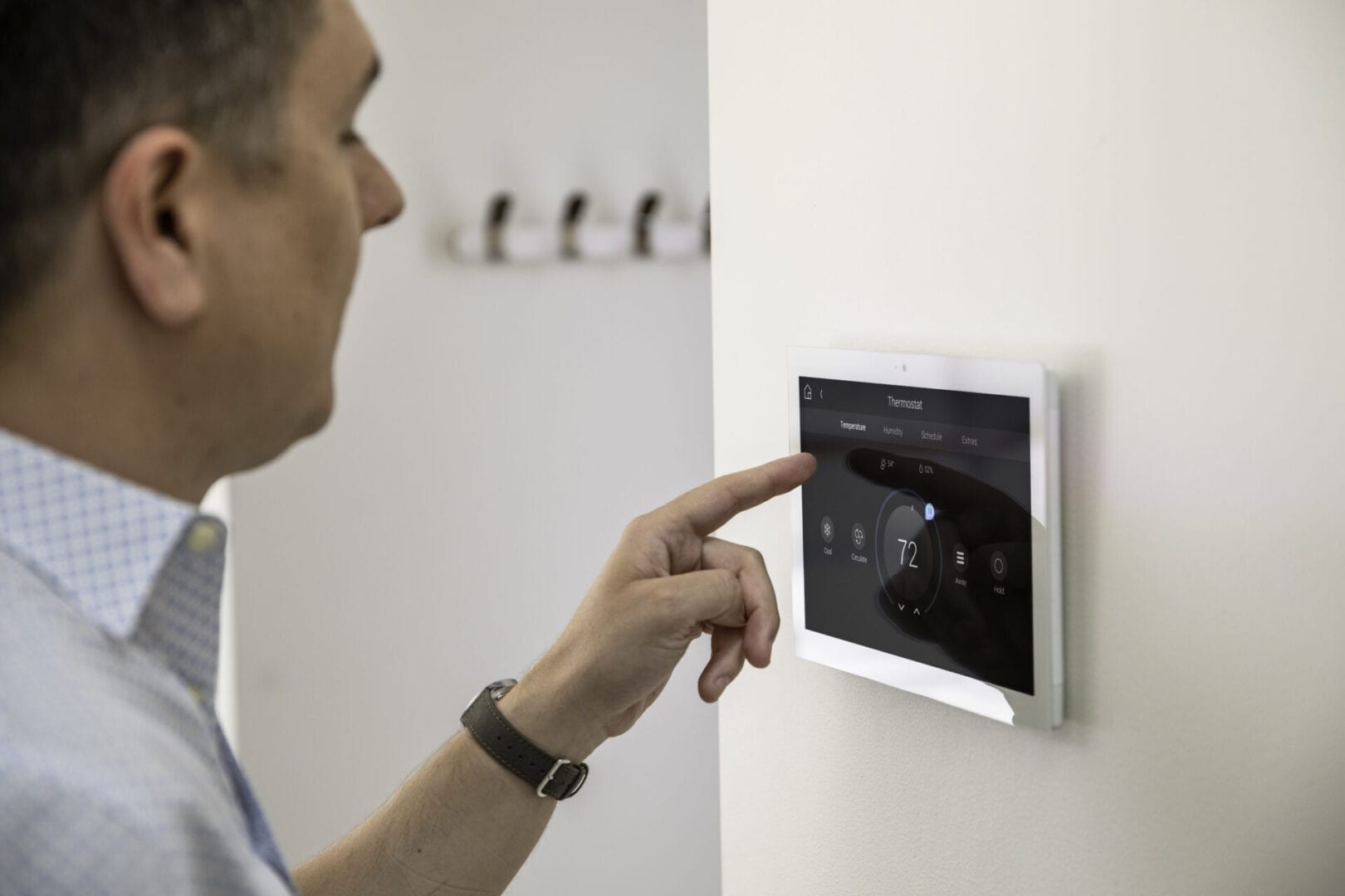 A man is pointing to the screen on a wall.