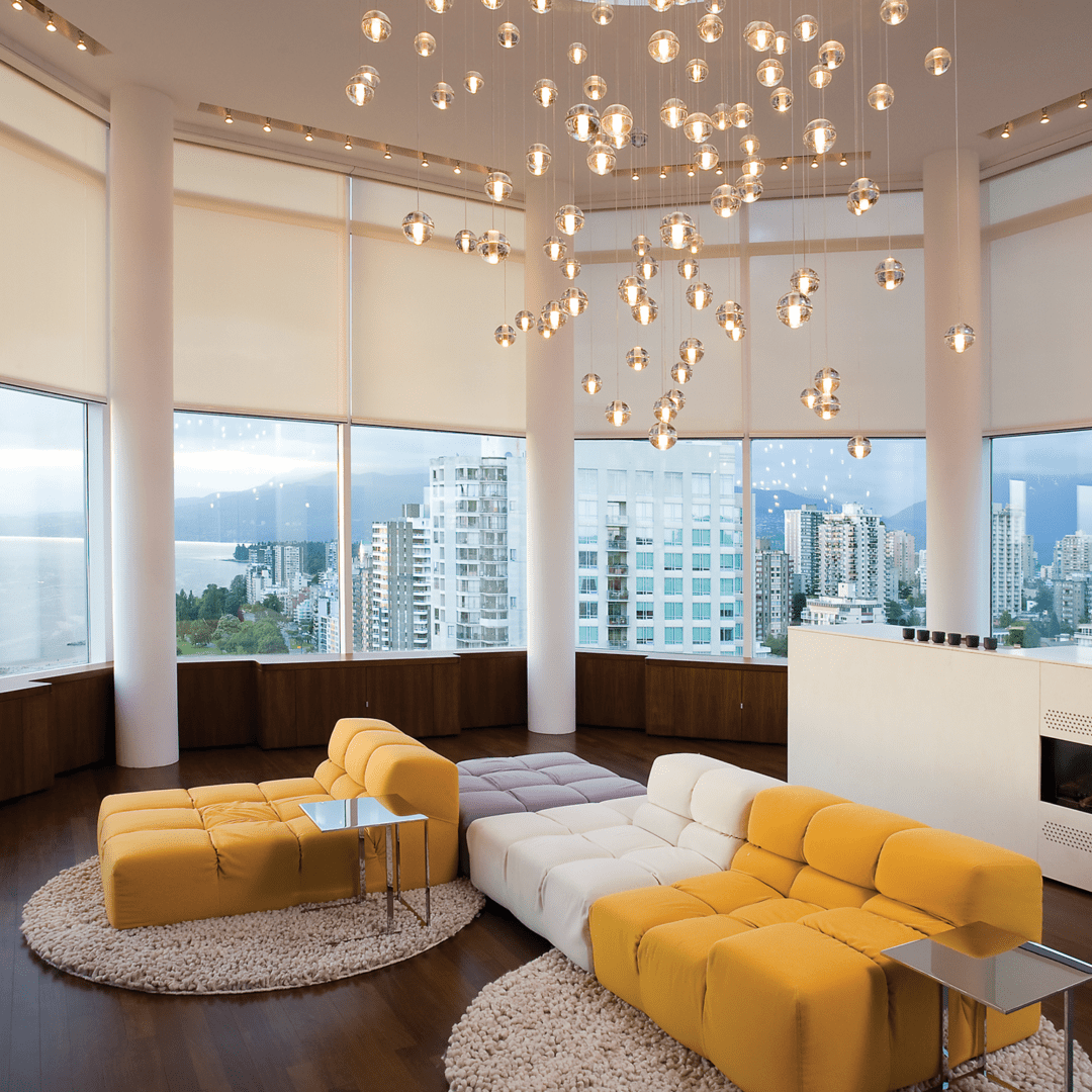 A living room with yellow furniture and a large window.